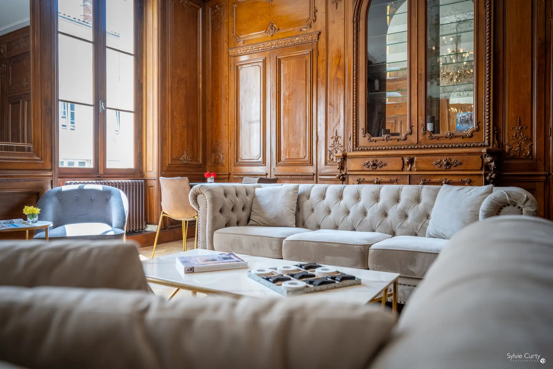 Classic lounge of Hôtel Le Champlain in La Rochelle with antique wood paneling and velvet sofas