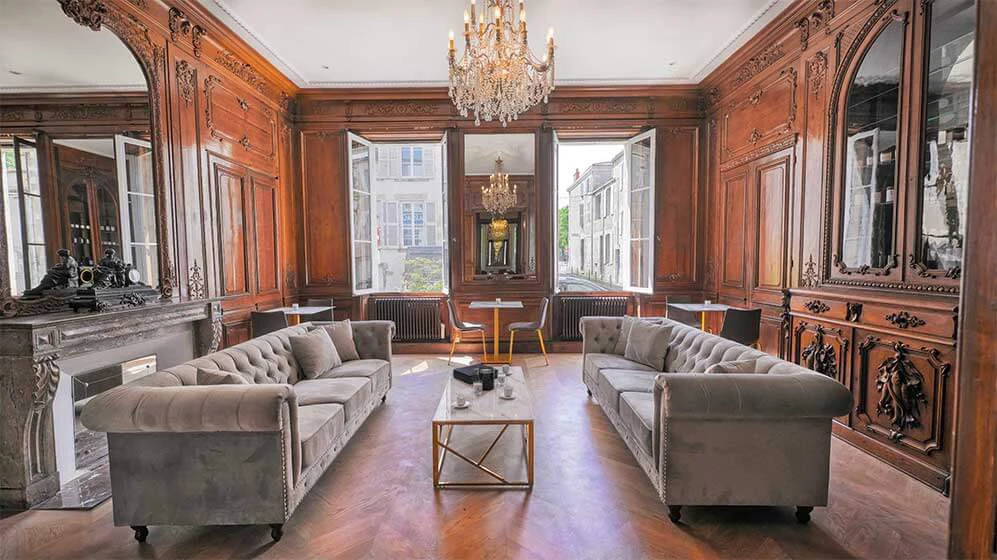 Bar salon historique Hôtel Le Champlain La Rochelle boiseries acajou sculptées 18e siècle lustre cristal canapés Chesterfield