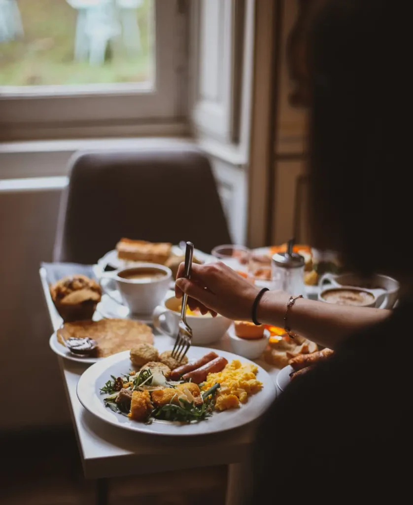 Brunch service chambre Hôtel Champlain La Rochelle plateau œufs brouillés saucisses café viennoiseries vue fenêtre jardin